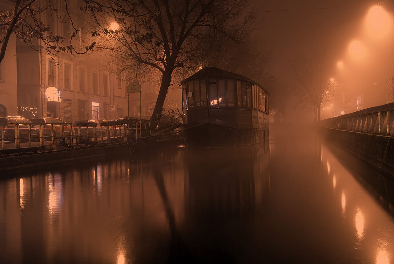 Una casa galleggiante sui Navigli di Milano in una sera di nebbia